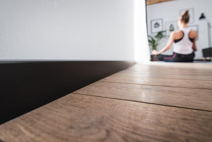 A lifestyle image of the Vox Evera skirting board  EV107 in colour Black.